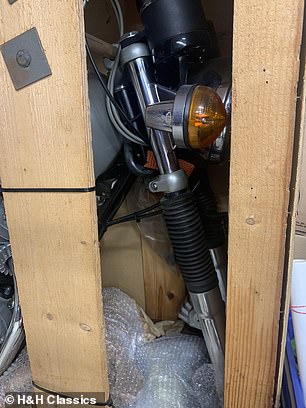 The front wheel is detached from the forks for easy storage in the wooden unit