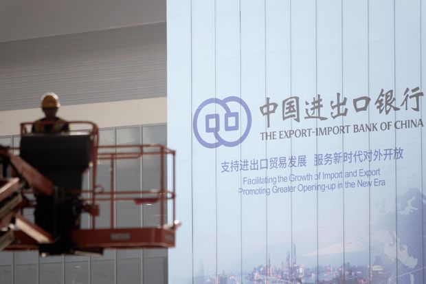 A worker operates near a sign for the Export-Import Bank of China, which has made...