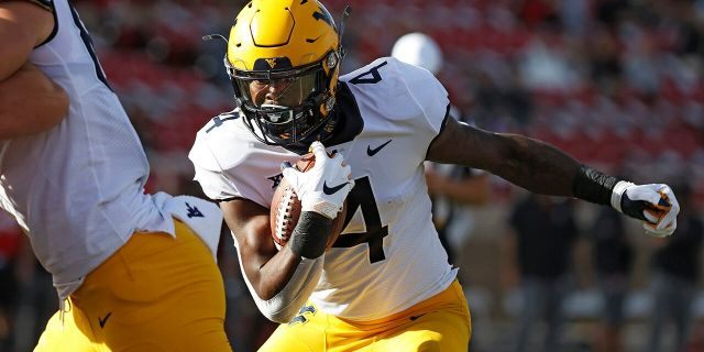West Virginia's Leddie Brown (4) runs the ball to score a touchdown during the first half of an NCAA college football game against Texas Tech, Saturday, Oct. 24, 2020, in Lubbock, Texas. (AP Photo/Brad Tollefson)