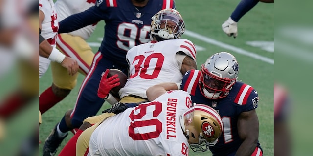San Francisco 49ers running back Jeff Wilson Jr. (30) spins to gains yardage behind the block of tackle Daniel Brunskill (60) in the first half of an NFL football game against the New England Patriots, Sunday, Oct. 25, 2020, in Foxborough, Mass. (AP Photo/Steven Senne)